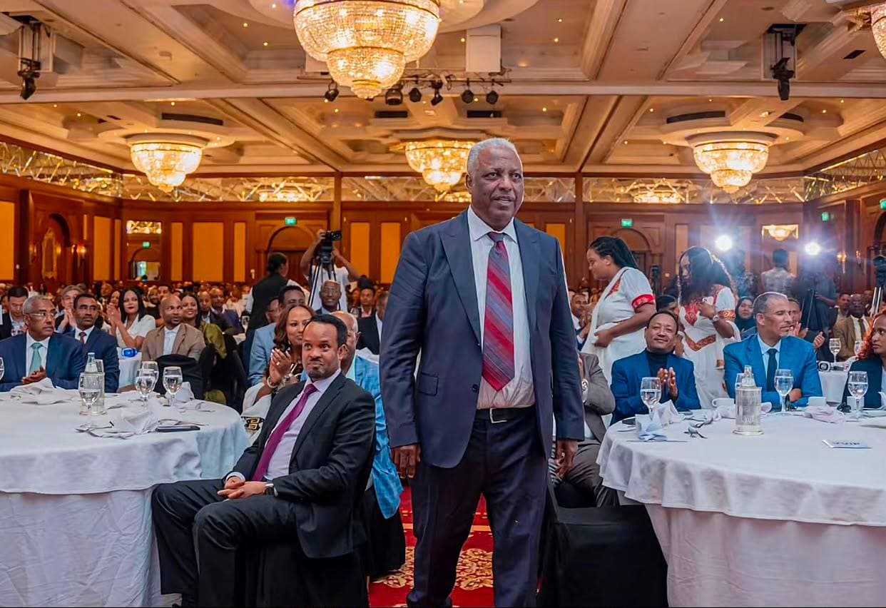 Guest of honour standing to applause among seated tables