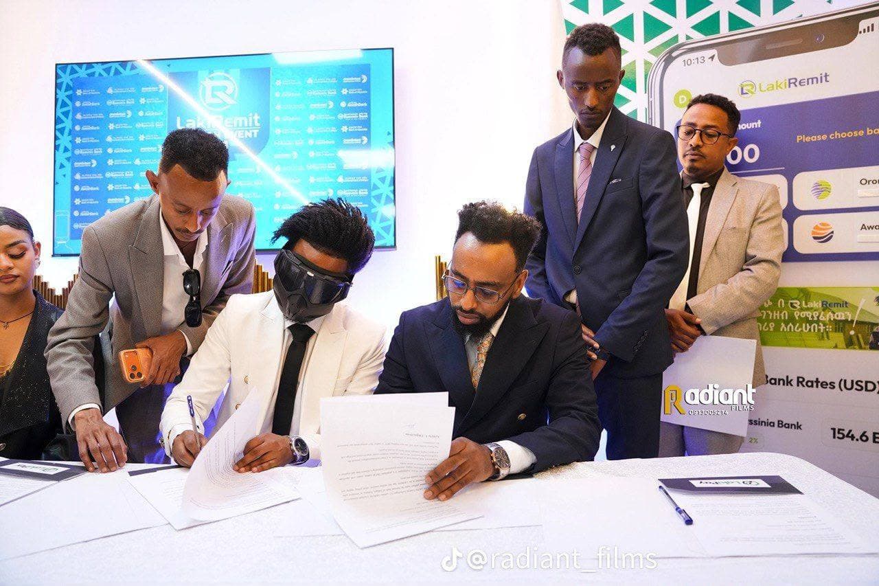 Signing ceremony at a remittance product launch with partner branding behind